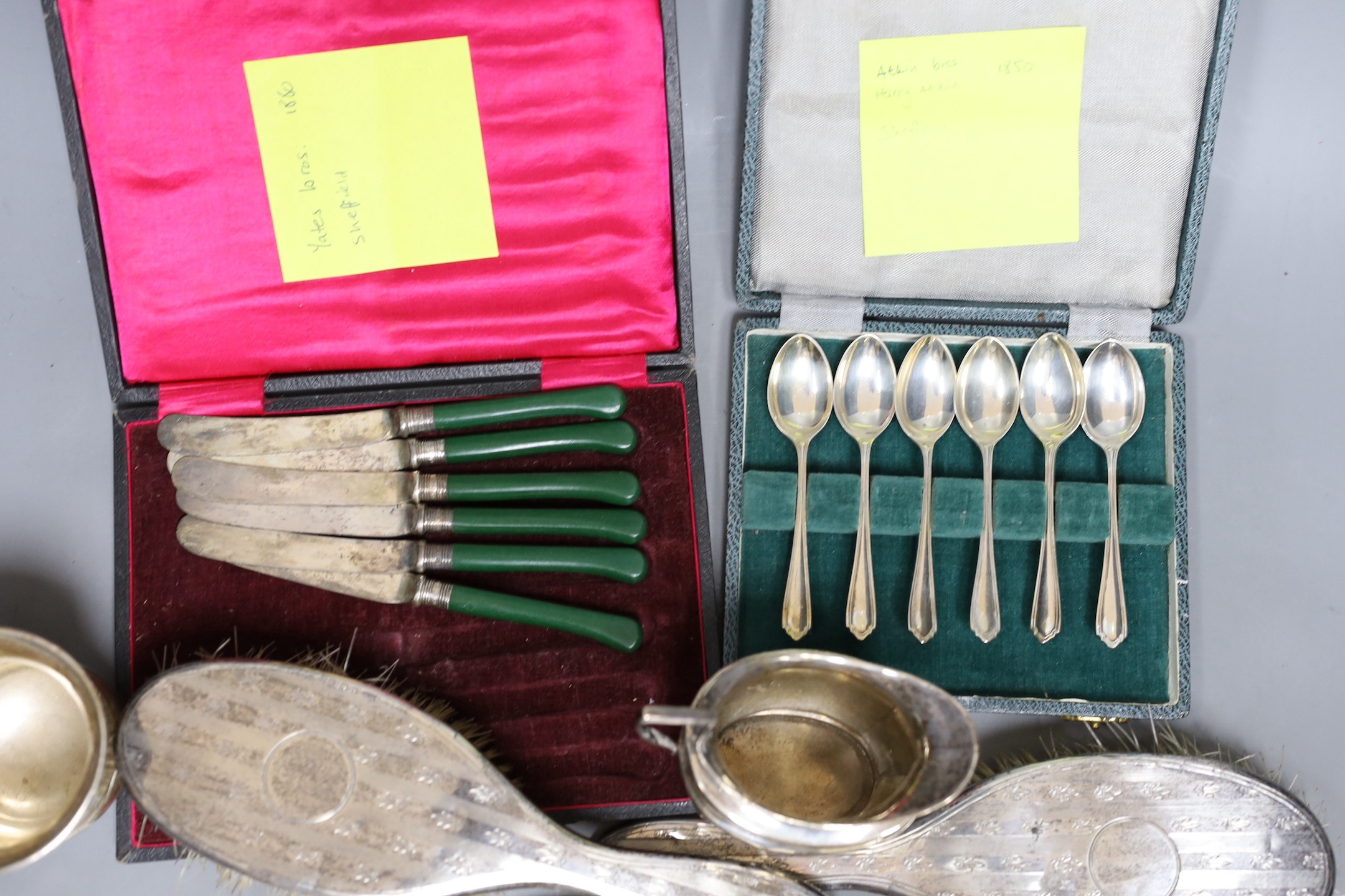 A small group of silver items including a tortoiseshell mounted hand mirror, London, 1917, two silver mounted clothes brushes, a cased set of six teaspoons, a mug and sugar bowl, together with a pair of plated candle snu